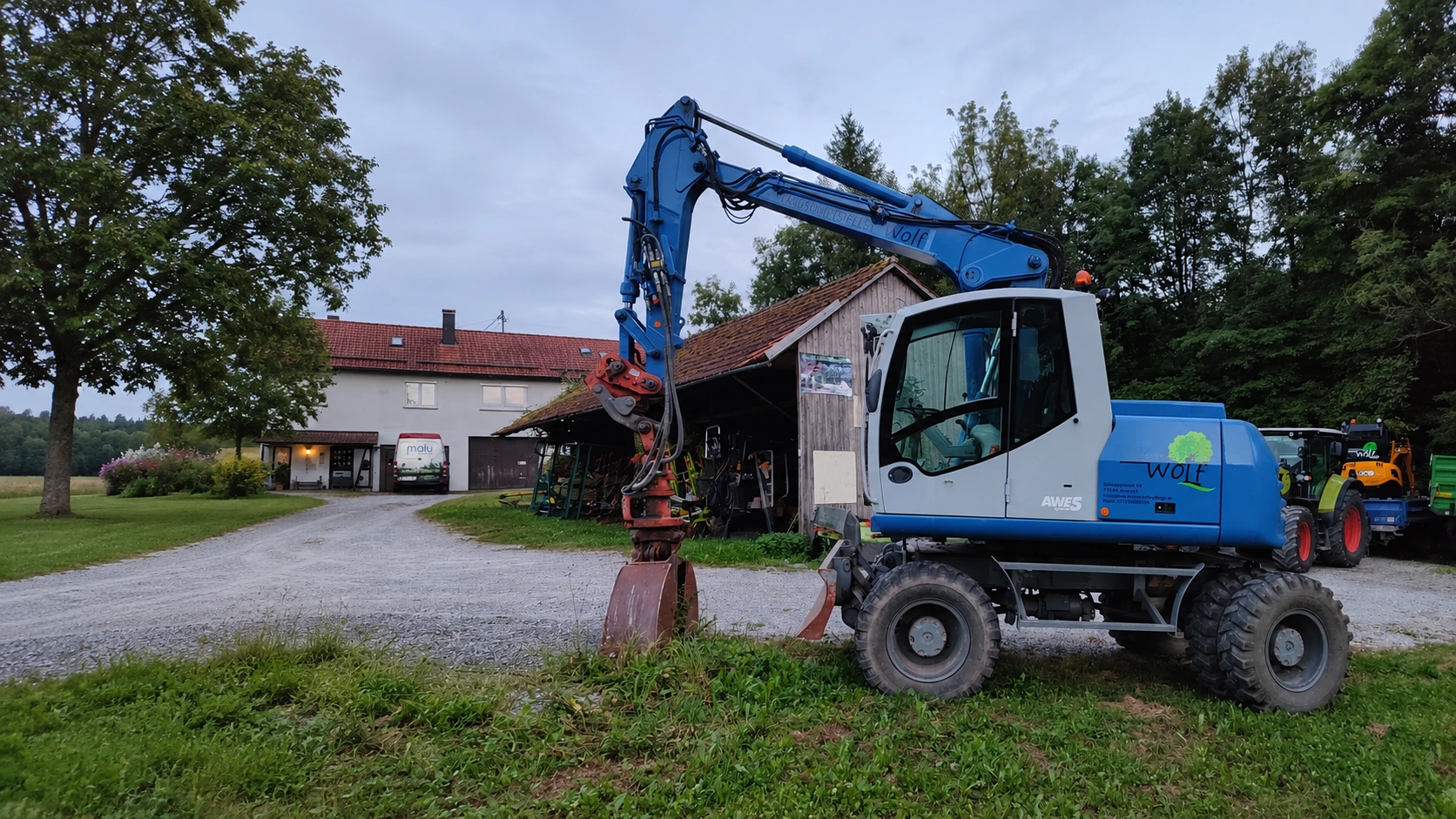 Blauer WOLF-Mobilbagger bei Erdarbeiten im Außenbereich
