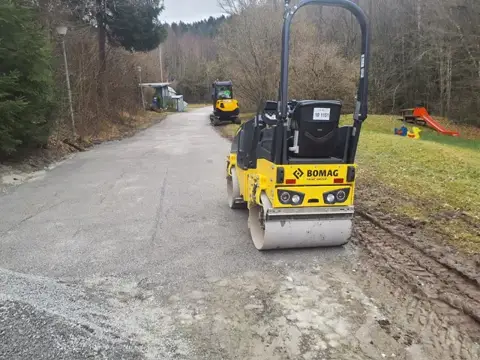 Verdichtung eines Schotterwegs mit der Walze