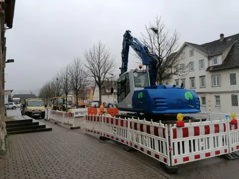 Mobilbagger auf einer abgesicherten Straßenbaustelle