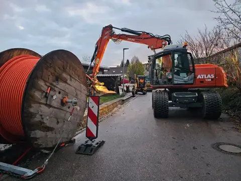 Leitungsarbeiten mit Kabeltrommel und Bagger